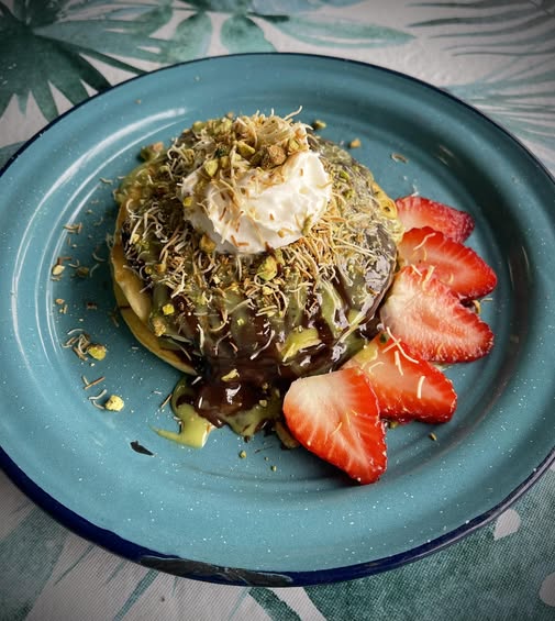 Crepas de pistacho con fresas, chocolate y crema batida